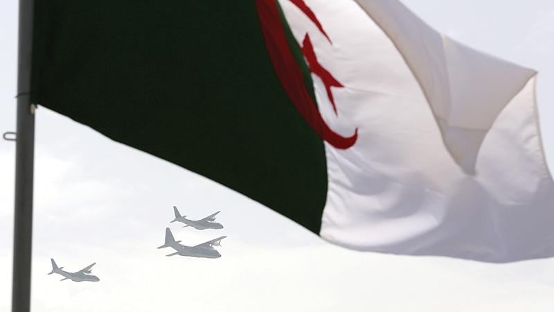 Algerian flag with military aircraft in background